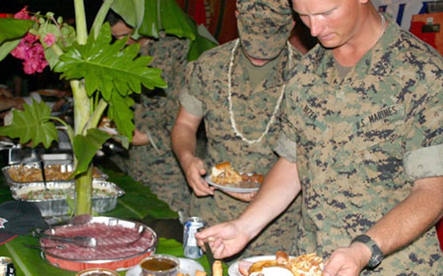 Marines with the 31st Marine Expeditionary Unit fill their plates during the barbecue party.