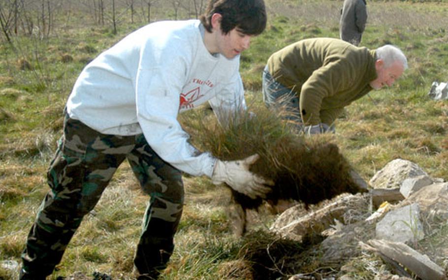 Lakenheath High School freshman Joseph Hartman, left, and Dave Nutt, natural resources manager for RAF Mildenhall, place sod on top of a construction rubble being made into a habitat for great crested newts. Hartman spearheaded the project; it is part of what he must do to earn an Eagle Scout badge.