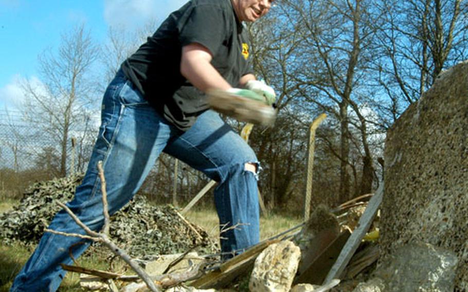 Lakenheath High School sophomore Dan Jones swings a sledgehammer toward a slab of concrete during an environmental project for great crested newts on April 10.