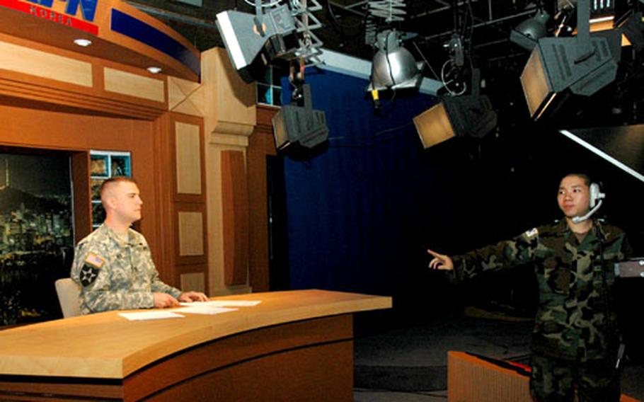 Staff Sgt. Alan Davis, left, and Pfc. Kim Eui-yong, a Republic of Korea soldier, practice Wednesday night’s broadcast.