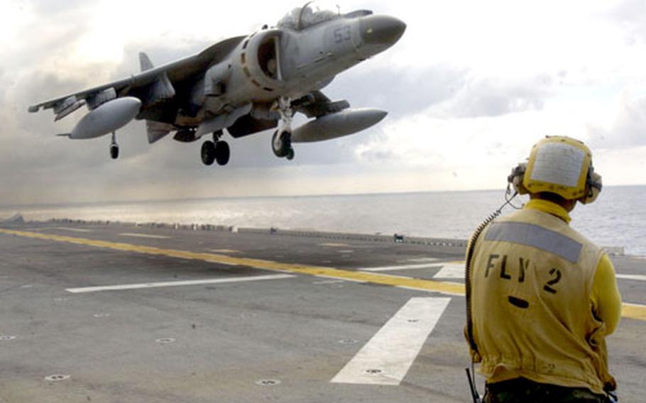 Navy Airman Isaac Berwick watches a AV-8B Harrier land on the flight deck of the forward-deployed amphibious assault ship USS Essex on Saturday. The Harrier is part of the 31st Marine Expeditionary Unit’s Marine Attack Squadron out of Iwakuni, Japan.