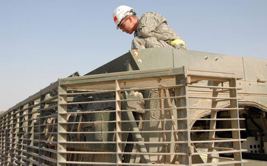 Spc. Harry Drum performs the early stages of the cleaning process for the Strykers. Before the slat armor around the Stryker is taken off, soldiers search for stray ammunition or anything else that might have fallen in the cracks during deployment. Among lots of trash, the soldiers have found knives, watches and iPods.