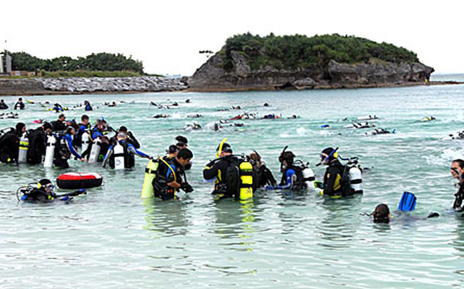 Divers shoot out into the water at Kadena Marina Saturday after the horn signals the underwater Easter egg hunt has begun. Seventy two teams of two participated in the hunt to find the 500 plastic eggs, with numbers inside for a raffle, dropped into the Marina the night before.