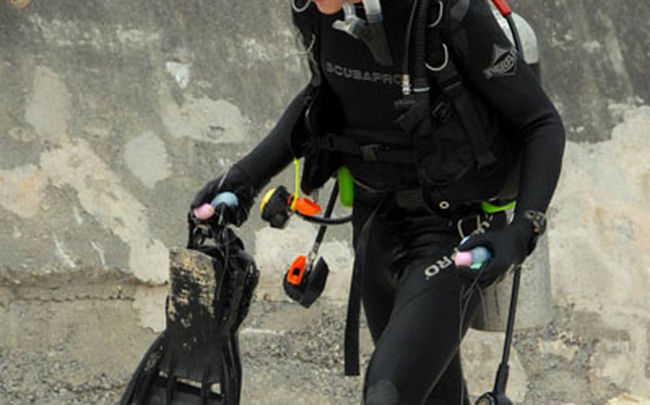 Marine Capt. Ken Belovarac walks up the beach from the water with his hands full of plastic eggs after participating in the underwater Easter egg hunt Saturday, where 144 people dived for eggs weighted down with anchors.