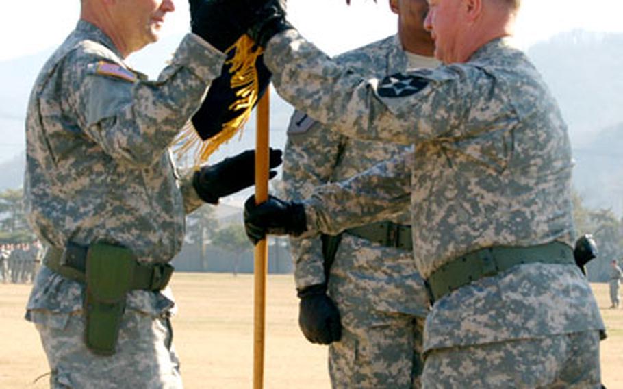 Outgoing 2nd Infantry Division commander Maj. Gen. James Coggin passes the division’s colors to 8th U.S. Army commander Lt. Gen. David Valcourt during the 2nd ID change of command ceremony Wednesday at Camp Casey.