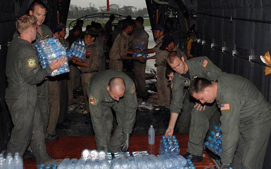 U.S. Air Force members from Yokota Air Base, Japan, assist people of Myanmar through the delivery of humanitarian relief supplies May 19. The U.S. military flew in 3.3 million pounds of relief supplies in the wake of a deadly typhoon that struck May 2. Most of the pallets were built and loaded by Marines with Combat Logistics Regiment 3 in Thailand.