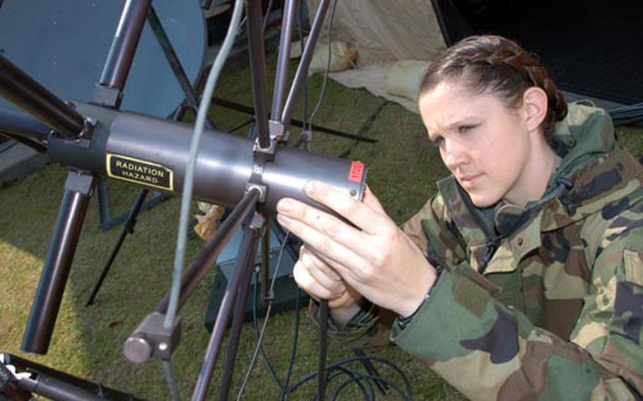 Petty Officer 3rd Class Katherine Waltz examines one of the antennas she&#39;s responsible for setting up as part of her duties with Fleet Maritime Patrol Mobile Operations Control Center West Pacific. The 12-member unit is based at Naval Air Facility Misawa, one of eight in the Navy and the only one in Japan. The team deploys to remote locations in support of P-3 Orion aircraft.