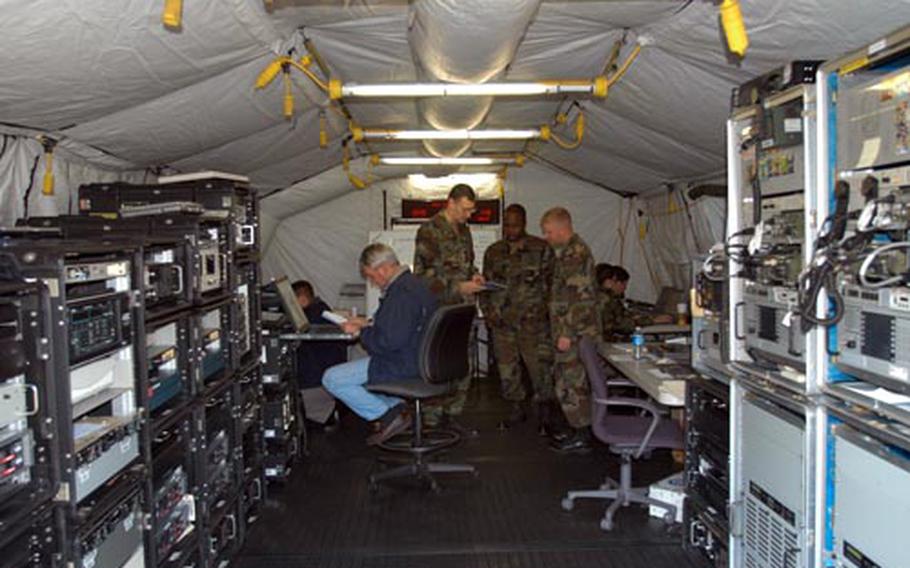 Sailors with Fleet Maritime Patrol Mobile Operations Control Center West Pacific, including center, from left standing, Chief Warrant Officer 3 Edward Heim, Petty Officer 2nd Class Freddie Thomas, and Petty Officer 1st Class Brent Borden, worked last week inside expeditionary tents at Naval Air Facility Misawa, Japan.