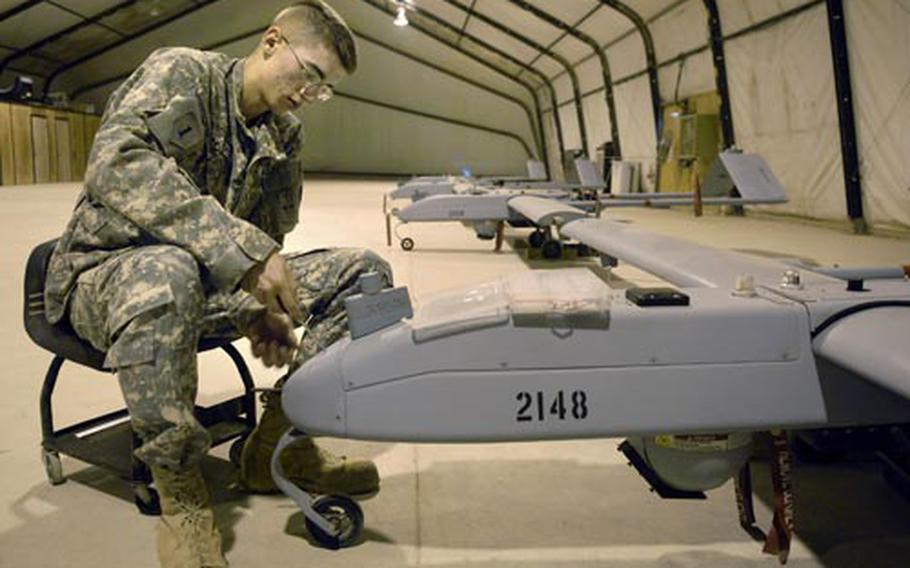 Spc. Daniel Dekorte, an unmanned aerial vehicle crew chief assigned to the 504th Military Intelligence Company, does a maintenance check on a Shadow 200 in a hangar at Forward Operating Base Kalsu.