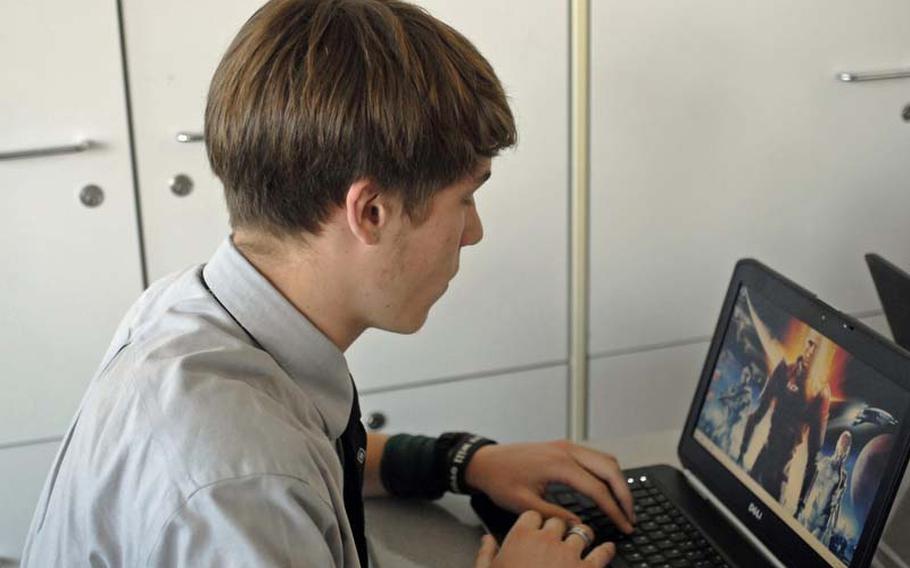 Wiesbaden High School senior Andrew Hemphill, 17, gets his laptop booted up before a class at the school. Wiesbaden is one of 10 DODDS schools where students and teachers are being issued laptops they use during the school year as part of a pilot program.