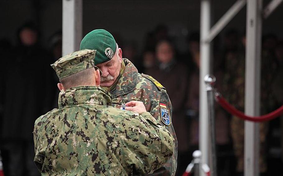 U.S. Adm. James G. Stavridis pins a NATO Meritorius Service Medal, the alliance's highest award, on German Gen. Wolf Langheld, who on Friday handed over command of NATO's Allied Joint Force Command Brunssum and will retire at the end of the month after 42 years of service.