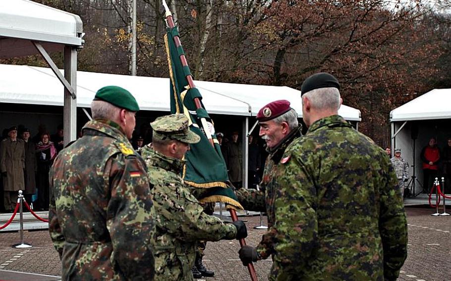 U.S. Admiral James G. Stavridis hands the colors of NATO's Allied Joint Forces Command Brunssum to German Gen. Hans-Lothar Domröse, who assumed command of the unit Friday.