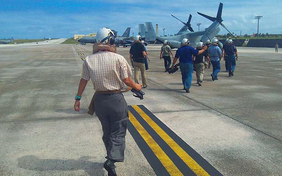 A group dignitaries, politicians and reporters walk toward the MV-22 Osprey on Thursday, Dec. 13, 2012 at Andersen Air Force Base. The Marines provided a "familiarization flight" on the helicopter-airplane hybrid while it's participating in exercise Forager Fury on Guam and Tinian.