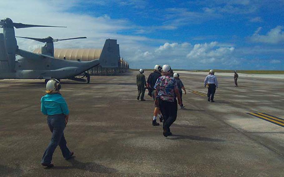 A group of civilian dignitaries, politicians and reporters walk toward the MV-22 Osprey Thursday, Dec. 13, 2012, at Andersen Air Force Base. They were invited by the Marines for a familiarization flight on the helicopter-airplane hybrid while the Marines took part in exercise Forager Fury on Guam and Tinian.