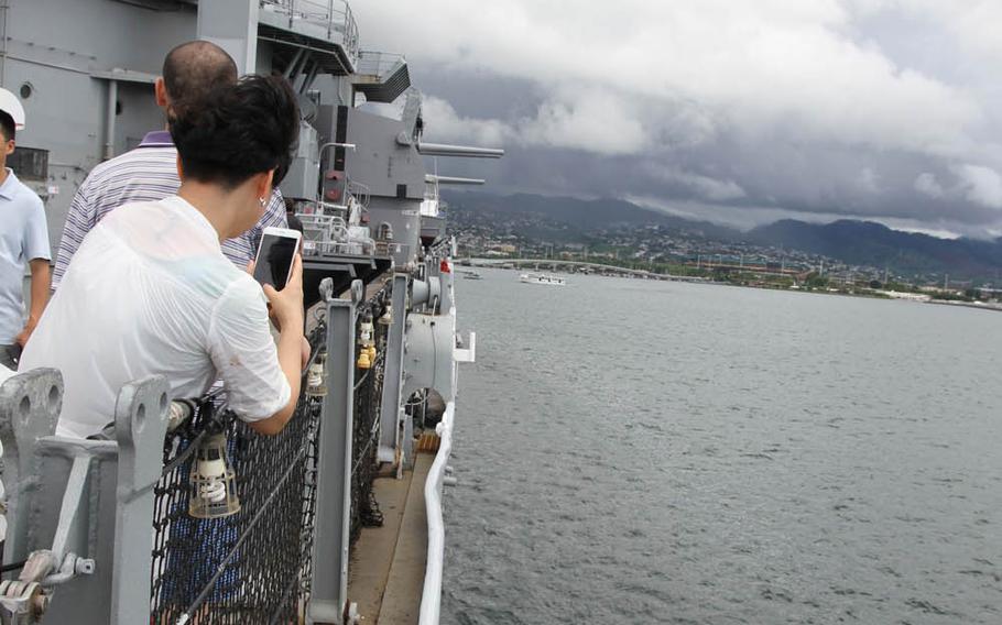 A visitor snaps a photo of the bent gunwale on the Missouri, the only scar remaining from a 1945 kamikaze attack on the ship during World War II's Battle of Okinawa.