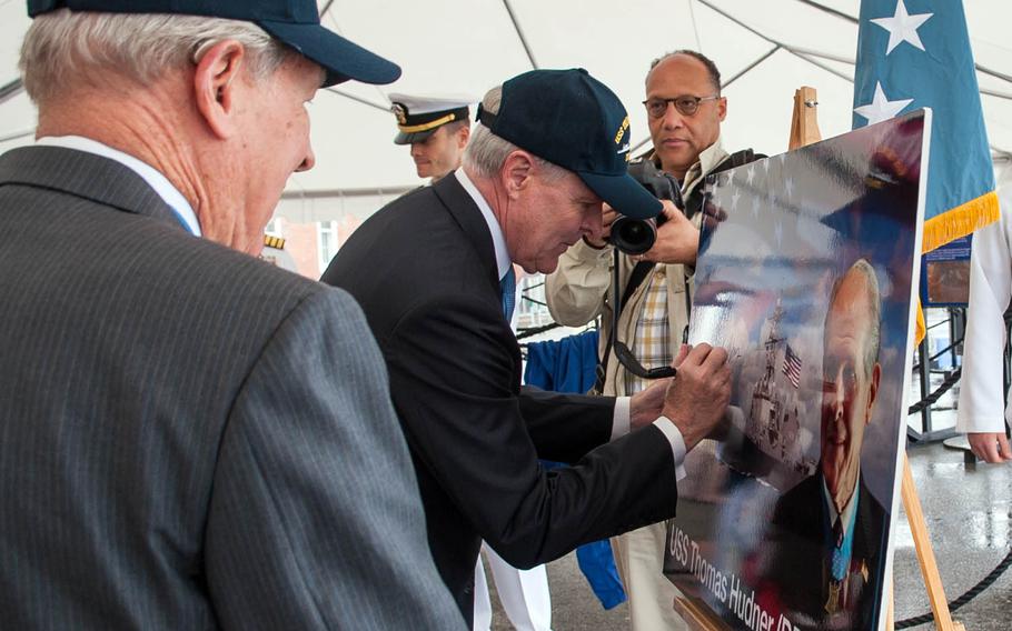 Then-Navy Secretary Ray Mabus signs an illustration of the guided-missile destroyer USS Thomas Hudner during a naming celebration in Charlestown, Mass., May 22, 2012.