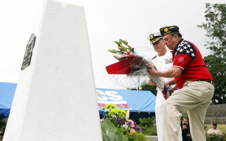 Capt. Robert Mathewson Jr., left, Okinawa Naval Base commander, and Brad Reeves, American Legion Post 28 vice commander, lay flowers at the Ernie Pyle memorial on Ie Shima, Okinawa, Sunday, April 22, 2018.
                