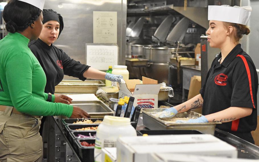 Cooks discuss food preparation at one of the USS Harry S. Truman's seven galleys on May 8, 2018, in the eastern Mediterranean. Culinary crews must be well-organized and work together to feed the ship's 5,500 sailors during a combat operation.