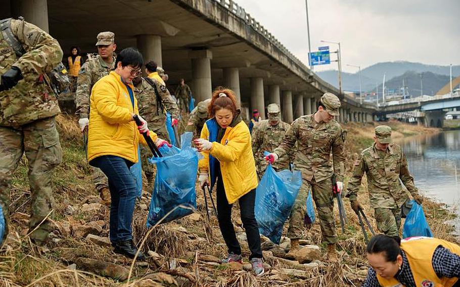 U.S. soldiers from Camp Casey and local volunteers clean up debris along the Shincheon River in Dongducheon, South Korea, Thursday, March 21, 2019.