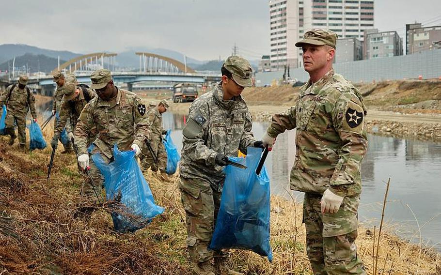 U.S. soldiers from Camp Casey clean up debris along the Shincheon River in Dongducheon, South Korea, Thursday, March 21, 2019.