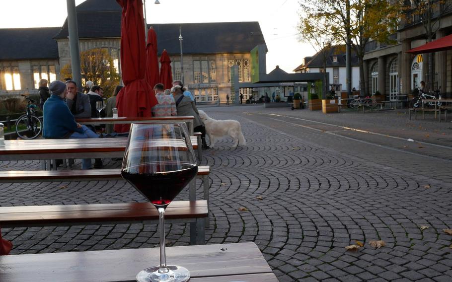 A glass of primitivo from the Puglia region of Italy at the Vinocentral in Darmstadt, Germany. In the background is the city's main train station.