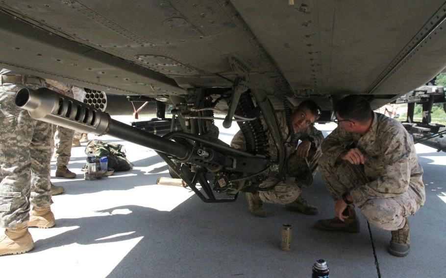 Prior to the battalion-wide exercise on June 9, 2015, where Marines were supported by South Korean-based U.S. Army Apache attack helicopters, the 3rd Battalion, 2nd Marine Regiment troops were given the opportunity to inspect the birds that would be flying overhead. Here, two Marines look closely at the Apache's chain gun. 