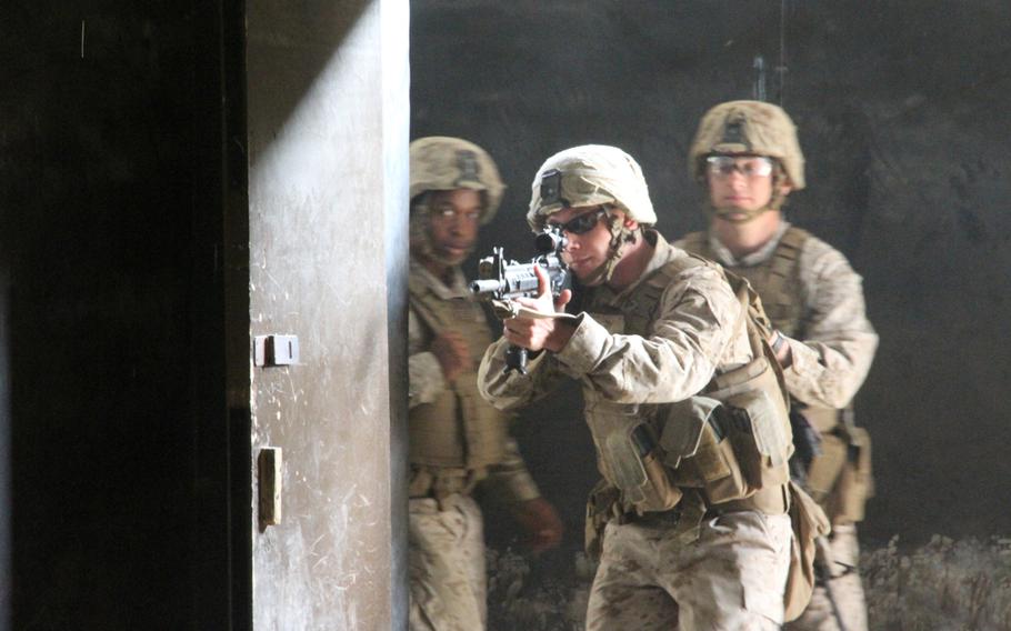 Lance Cpl. John Brooks Jr. enters the live-fire shoot-house at Rodriguez Live Fire Complex near the Demilitarized Zone in June. The Marines were closely scrutinized from behind and from above as they moved through the house, clearing rooms, and eliminating enemy targets. 