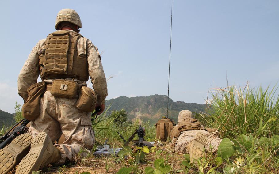 First Lt. Billy Grissom III, left, and 1st Lt. Miles Essay watch as a mortar hits its target halfway up the mountain in front of them during a battalion-wide exercise June 9, 2015, at the Rodriguez Live Fire Complex near the Demilitarized Zone. 
