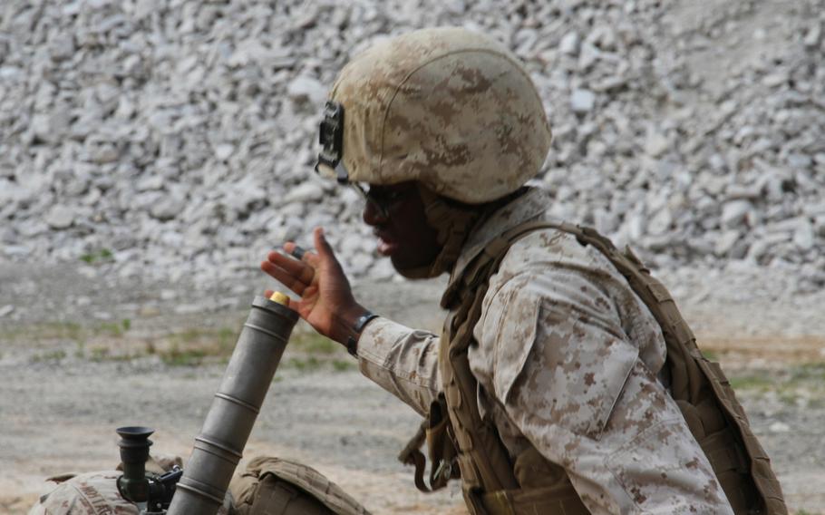 Lance Cpl. Khadeem Jeffers, a weapons platoon mortarman, releases a mortar into the tube during a battalion-wide exercise June 9, 2015, at the Rodriguez Live Fire Complex near the Demilitarized Zone. 