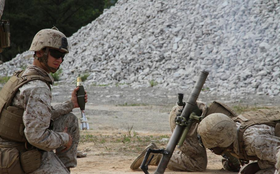 Lance Cpl. Khadeem Jeffers, right, ducks as a mortar fires during a battalion-wide exercise June 9 at the Rodriguez Live Fire Complex, south Korea. Cpl. Cody Johansen, left, readies another round. 

