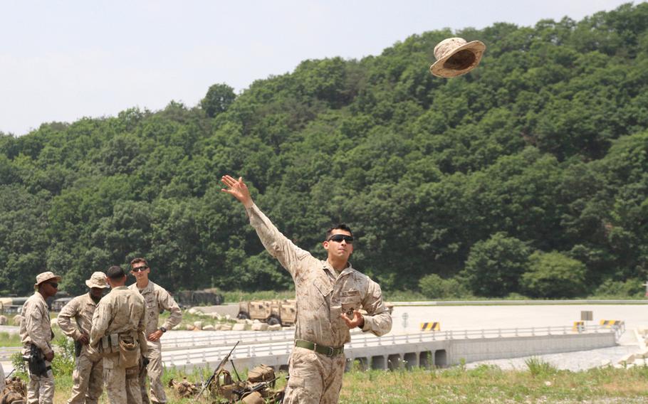 Newly minted Cpl. Eduardo Rodriguez used his boonie cap as a frisbee while waiting several hours for a battalion-wide exercise to commence June 9, 2015, at the Rodriguez Live Fire Complex, South Korea. 
