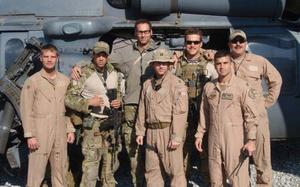 At 6-foot-8, Master Sgt. Roger Sparks towers over the team of pararescue jumpers and pilots he worked with during deployment to Afghanistan in 2010. His right arm is around Capt. Koaalii Bailey, who was on the ground with Sparks on Nov. 14, 2010.