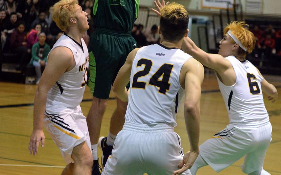 Kubasaki's Jonathan Baker shoots over three American School In Japan defenders during Monday's semifinal game in the Far East Boys Division I Basketball Tournament. The Mustangs prevailed over the Dragons 75-60 and reached their first final since winning the title in 2013.