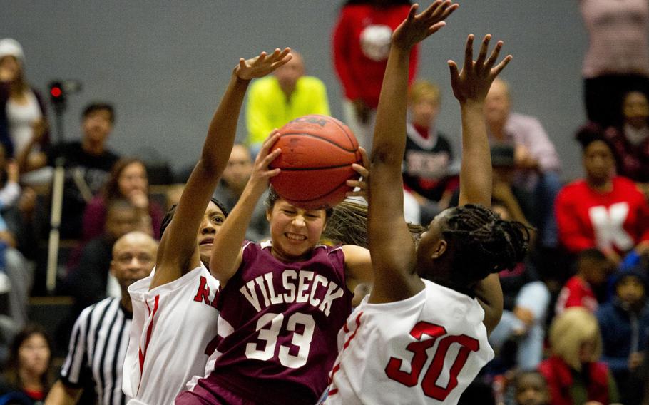 Vilseck's Adlynn Huego goes up for a shot between Kaiserslautern's Imaya Sharpe, right, and Aylonna Robinson at Vogelweh, Germany, on Friday, Dec. 1, 2017.