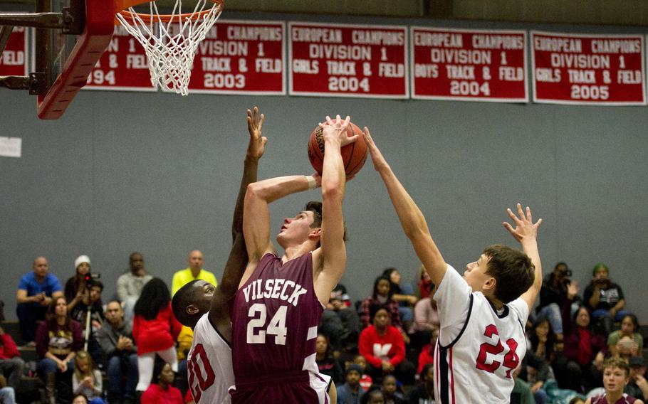 Vilseck's Tim Simmons goes up for a shot over Kaiserslautern's Marlon Robbins, left, and Isaak Pachelo at Vogelweh, Germany, on Friday, Dec. 1, 2017.