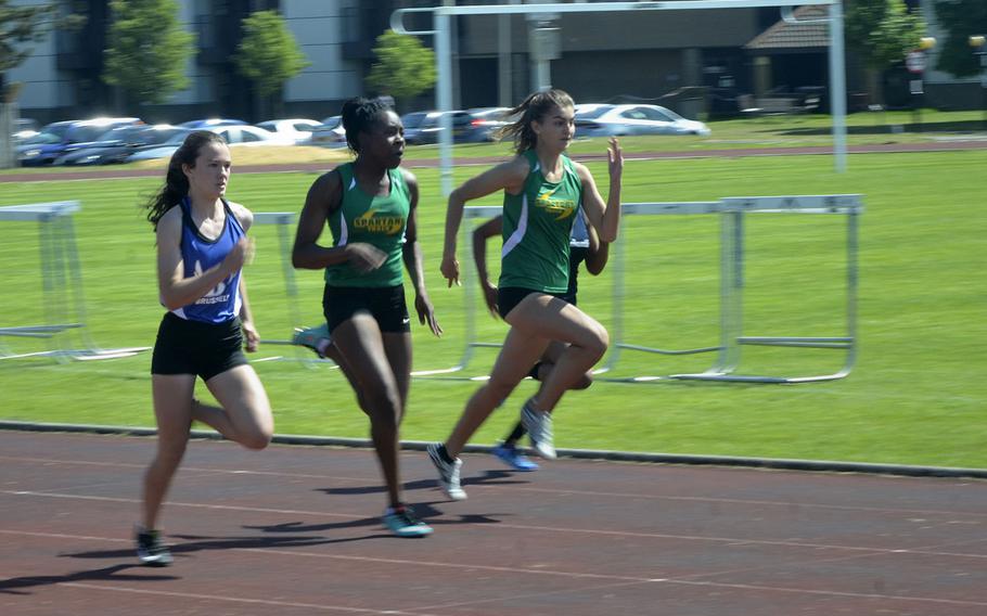 Sprinters from SHAPE and Brussels lead the pack in the 100-meter dash event during a high school track meet at RAF Lakenheath, England, Saturday, May 19, 2018. SHAPE runner Alexia Tarvis earned first place with a 13.21 second finish.