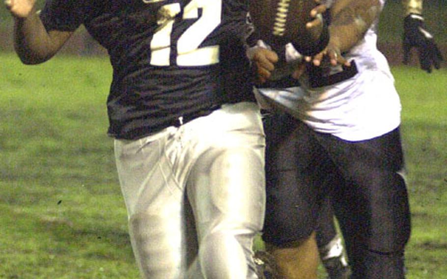 Quarterback Jacob Dowdell of the Yokota Raiders is hounded by a pair of Yokosuka Seahawks defenders during Saturday&#39;s U.S. Forces Japan-American Football League game at Bonk Field, Yokota Air Base, Japan. Three-time defending champion Yokosuka down Yokota 22-8.