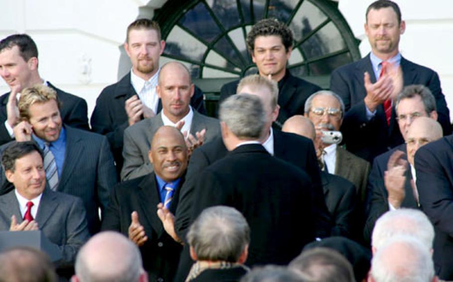Red Sox players, coaches and officials applaud President Bush as he arrives for Wednesday&#39;s ceremony on the South Lawn of the White House.