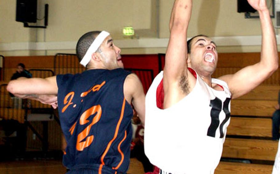 James Dunmore, right, of Landstuhl Regional Medical Center grasps a rebound in front of Pablo Reid of V Corps in the championship game of the unit-level tournament on Sunday in Würzburg, Germany.