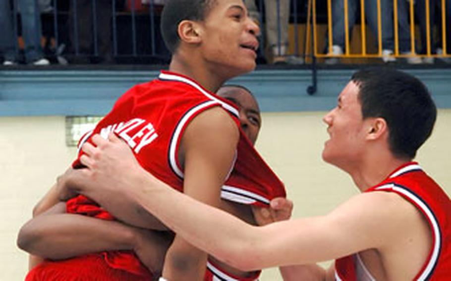 Bitburg’s Charles Whatley is congratulated by teammates after scoring the winning basket with less than 10 seconds to play during a DODDS-Europe high school basketball game in Wiesbaden, Germany, on Friday. Whatley stole the ball, drove in for a basket was fouled. He converted the three-point play to give Bitburg the 56-53 victory.