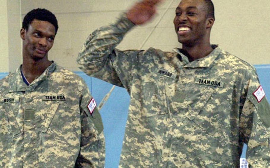 Team USA and Orlando Magic center Dwight Howard salutes about 1,000 servicemembers at Camp Casey&#39;s Carey Gym on Wednesday. At left is Chris Bosh of the Toronto Raptors.