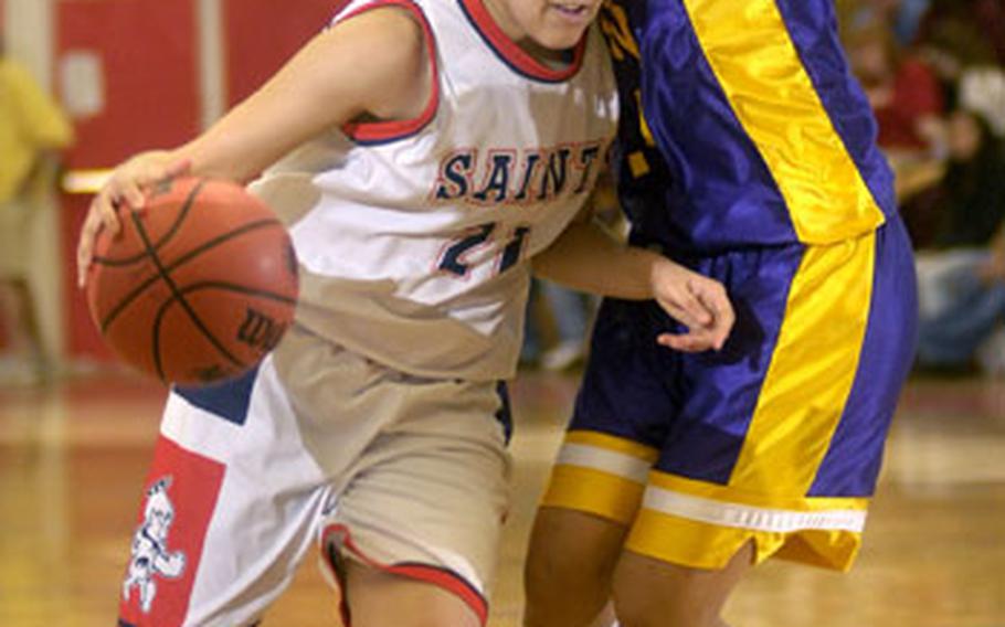 Aviano junior Alyssa Lane drives past Valerie Sasa of Mannheim during the second half of their Division II championship game Saturday at the Mannheim sports arena. Mannheim defeated Aviano 41-33.