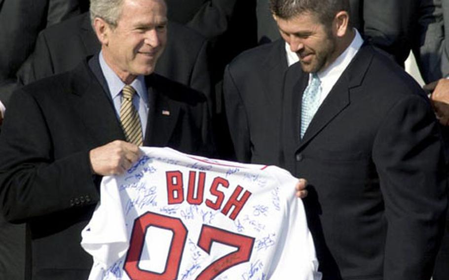 U.S. President George W. Bush (L) accepts a jersey from Boston Red Sox team  captain Jason Varitek (L) as Bush honored the 2007 World Series Champions,  the Boston Red Sox, on the