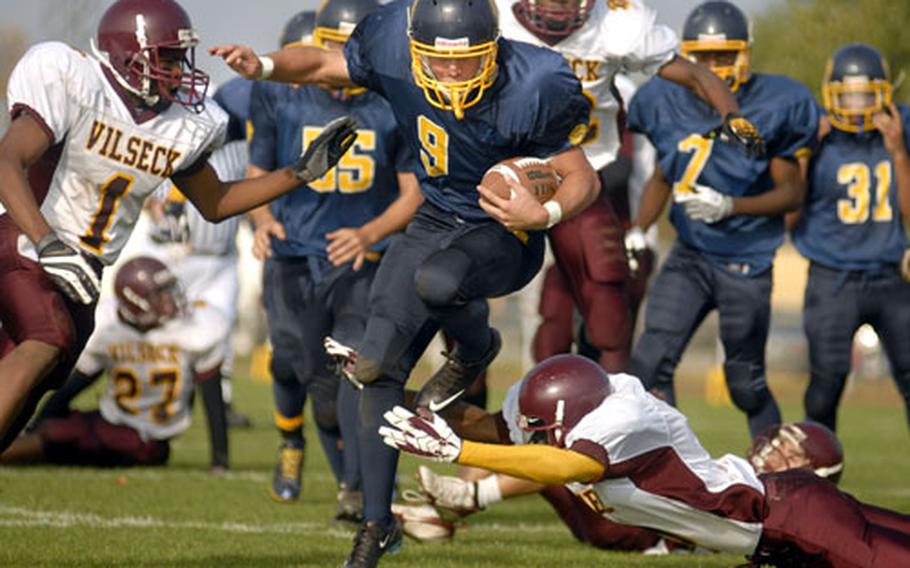 Heidelberg senior Kyle Ulses dances through the hands of a Vilseck defender early in the third quarter Saturday at Heidelberg. Ulses scored all four of Heidelberg&#39;s TDs in a 27-7 win that ended Vilseck&#39;s undefeated season and gave the Lions the Division I-South title.