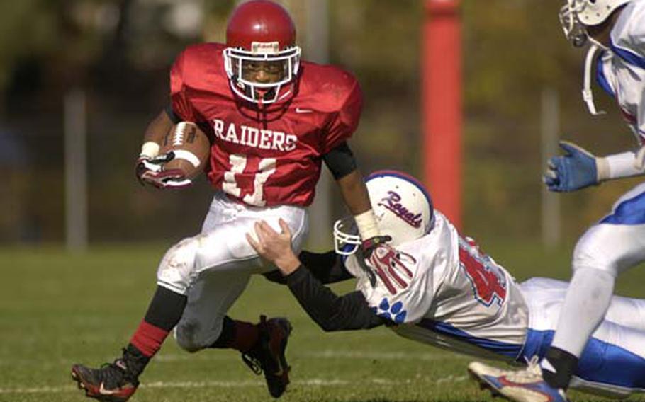 Kaiserslautern senior Khairi Smith breaks away from David Hanson of Ramstein during a kick return Saturday at Vogelweh. Ramstein defeated Kaiserslautern 20-7, to grab a home berth in next weekend&#39;s Division I playoffs.