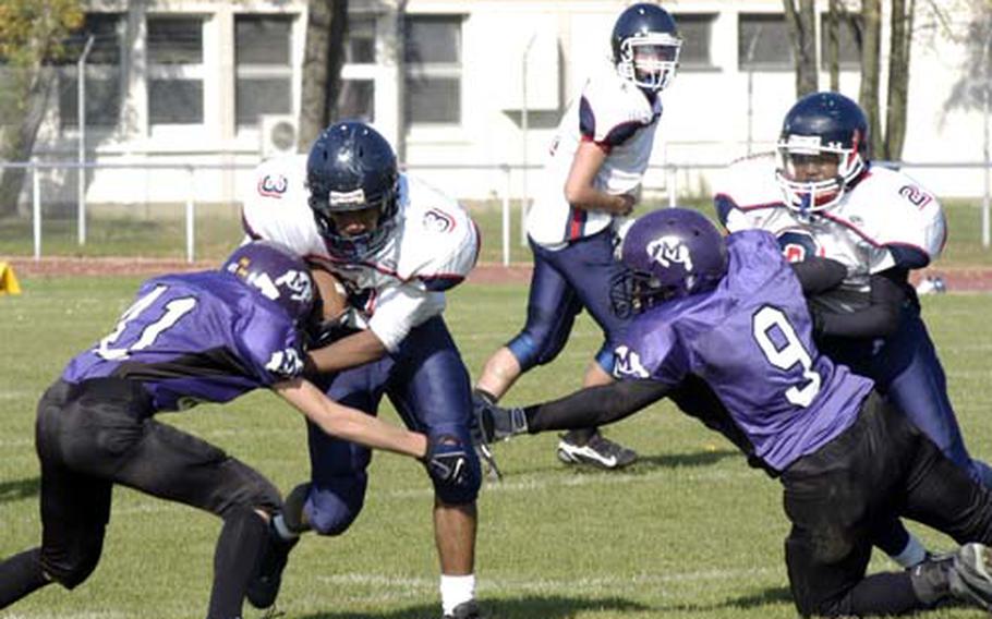 Bitburg senior Darius Wynn splits Mannheim defenders Jacob Bogden and Marcus Camps (9) on a run during his team&#39;s 35-8 drubbing of Mannheim on Saturday. Wynn ran for 112 yards and a touchdown in the victory.