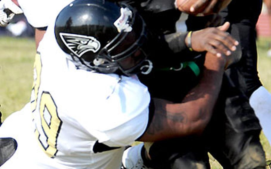 Kadena Dragons RB Desmond Fagan gets wrapped up by Anthony Wilson and Geoffery Coleman of the Yokosuka Seahawks.