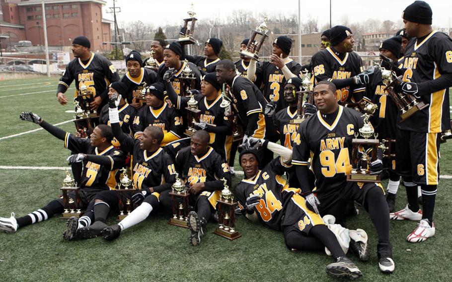 The victorious Army team celebrates with its championship hardware after Saturday's Army-Navy flag football game at Sims Field, Seoul American High School, South Korea. Army prevailed over Navy 12-6 in overtime.