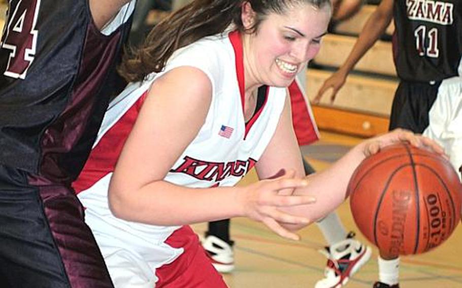 Nile C. Kinnick's Emily Stith has her path to the basket blocked by Briana Myrick of Zama American during Thursday's first-round game in the 5th DODDS-Japan Basketball Tournament at Yokota High School,  Japan. Kinnick beat Zama, 41-21.