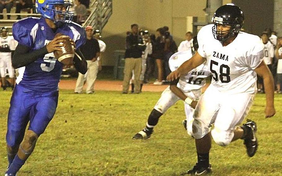 Yokota Panthers quarterback Stanley Speed looks to throw as Zama American Trojans defender Yoshi Nicolas gives chase during Friday's DODDS Japan/Kanto Plain Association of Secondary Schools football game at Yokota High School, Japan. Yokota won 47-7 and clinched its 12th DODDS Japan title in 13 seasons.